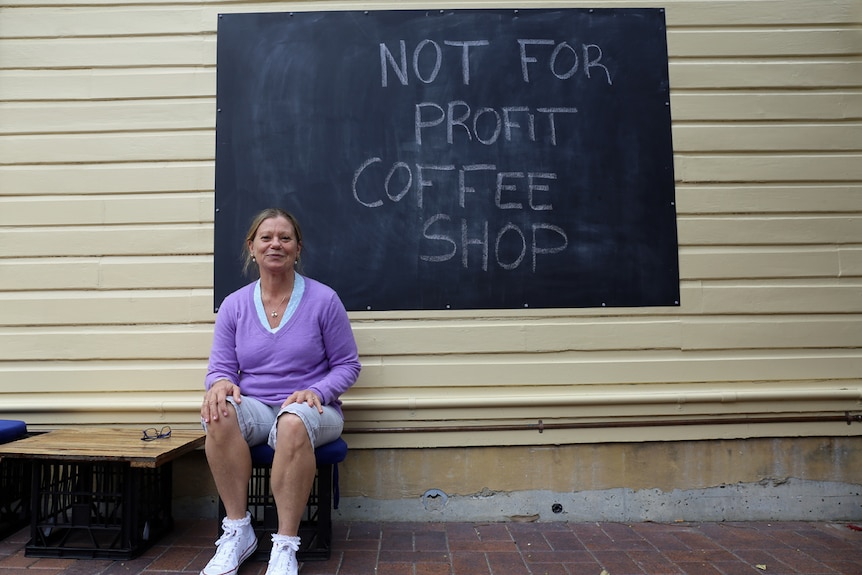 Sharon Sweeney next to coffee sign