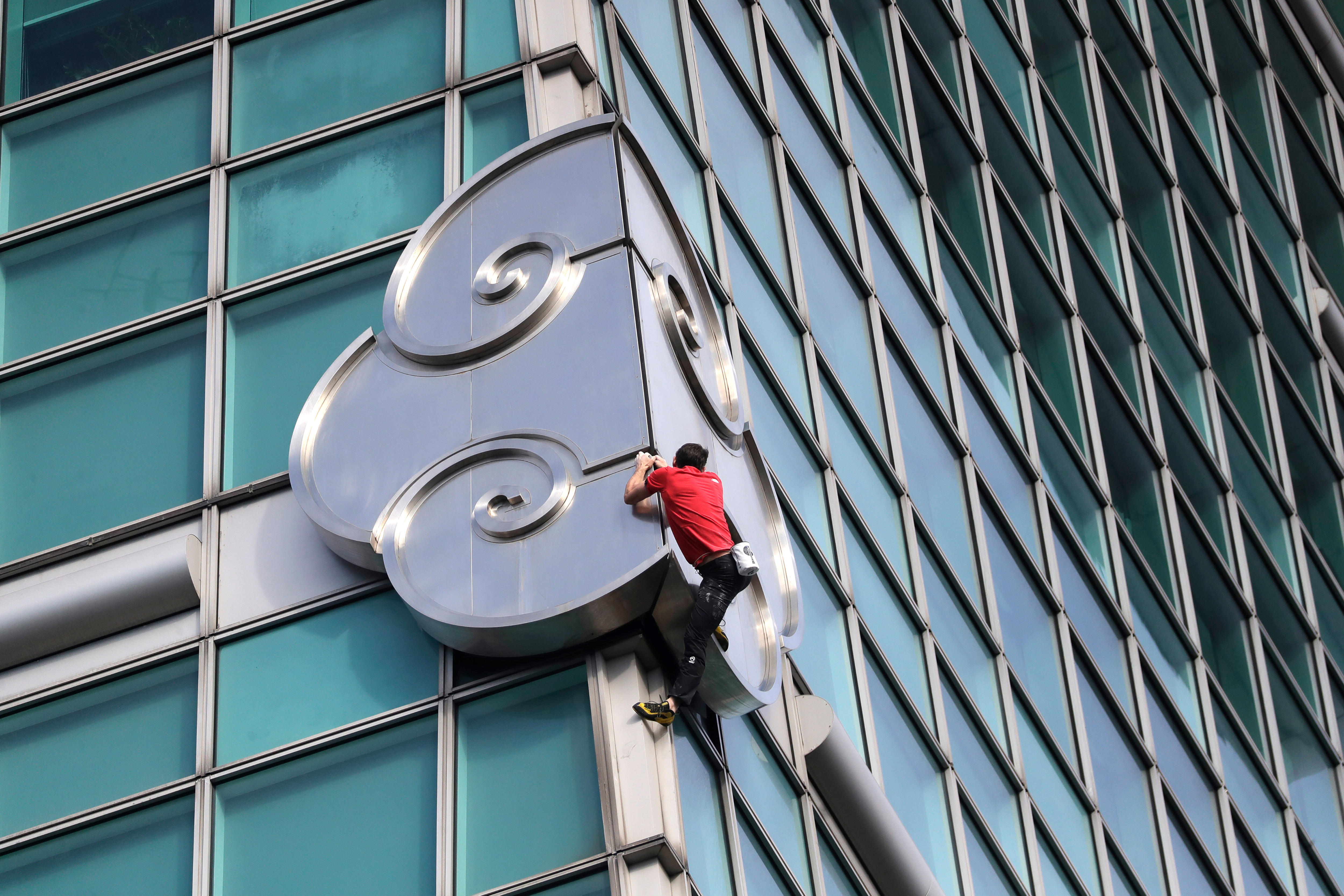 Alex Honnold se agarra al costado de un rascacielos. 