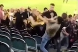 Two footy fans brawl at the MCG.