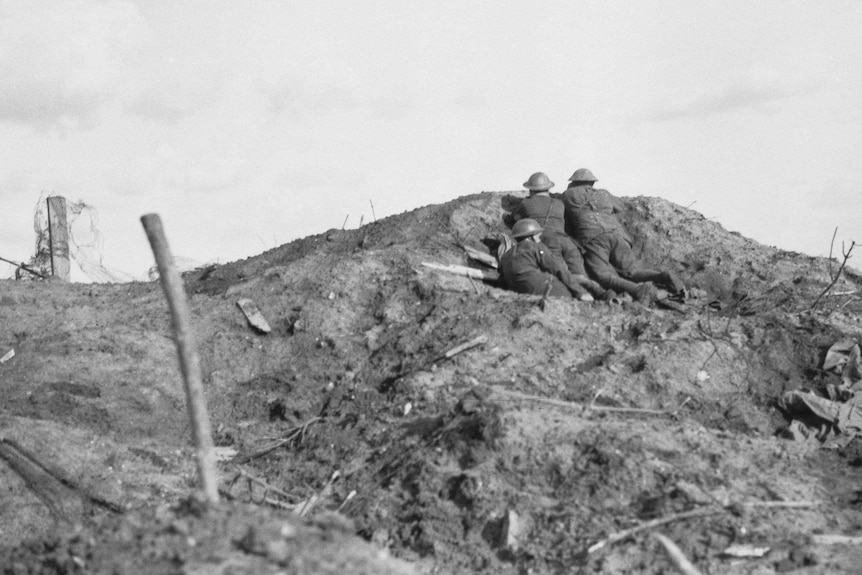 Black and white photo of troops on a muddy hillside.