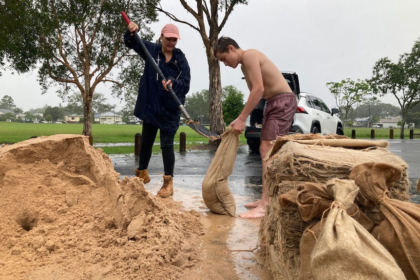 two people putting sand into bags