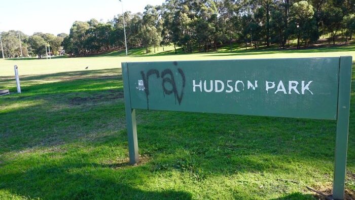 A sign of Hudson park in Newcastle with graffiti on it
