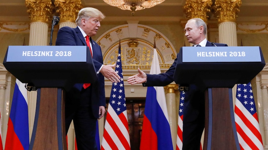 US President Donald Trump and Russia's President Vladimir Putin shake hands during a joint news conference