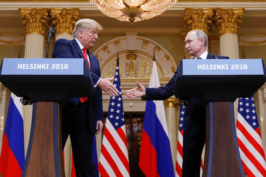 US President Donald Trump and Russia's President Vladimir Putin shake hands during a joint news conference