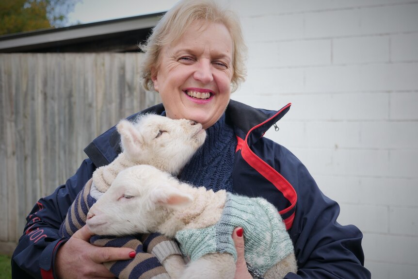 A woman with two small lambs