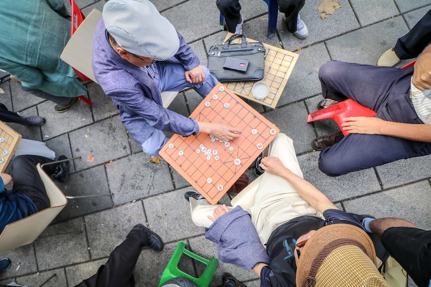 An overhead shot of men playing Chinese chess