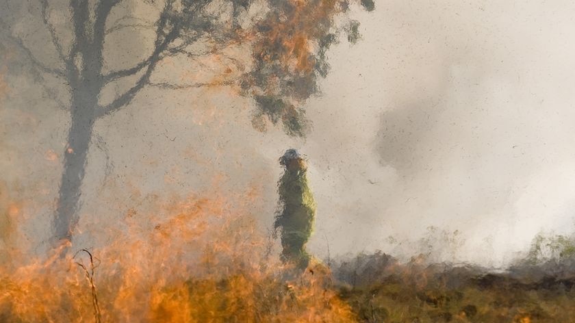 Qld firefighter surrounded by flames in a bushfire in Qld