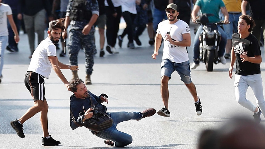 A man screams as he falls to the ground while being attacked.