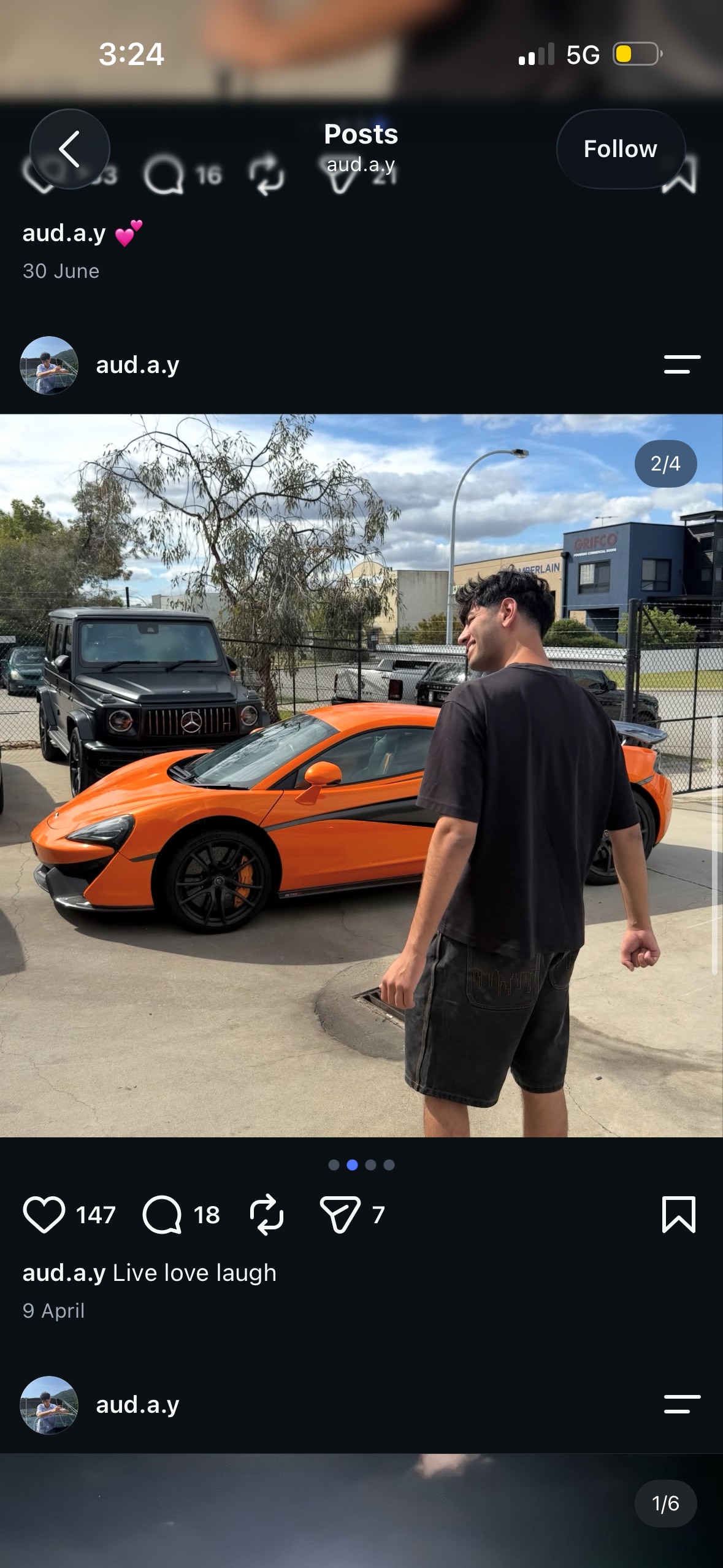 A man wearing black top with back to camera standing in front of orange luxury car