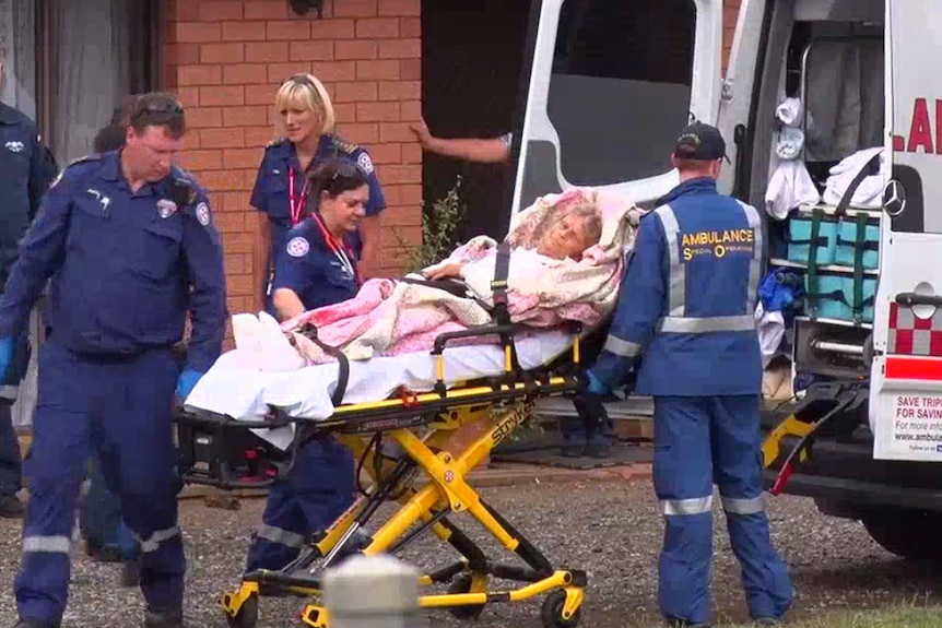 Woman being taken away in an ambulance.