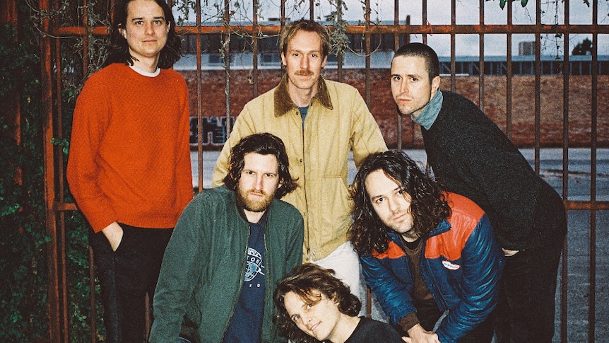 Current line up of King Gizzard and The Lizard Wizard, standing in front of gate