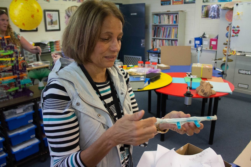 Image of a woman holding part of a balloon car, built by students at Kalgoorlie-Boulder Community High School.