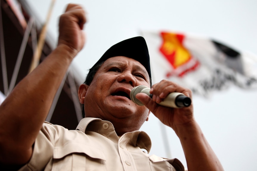 Prabowo Subianto speaks into a microphone. 