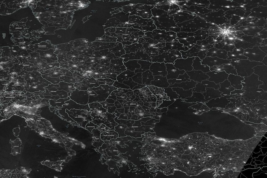 Ukraine is seen in darkness in a greyscale satellite image indicating the night radiance of Europe