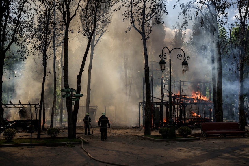 러시아군이 하르키우의 공원에서 폭격을 가한 후 소방관들이 화재를 진압하고 있다.