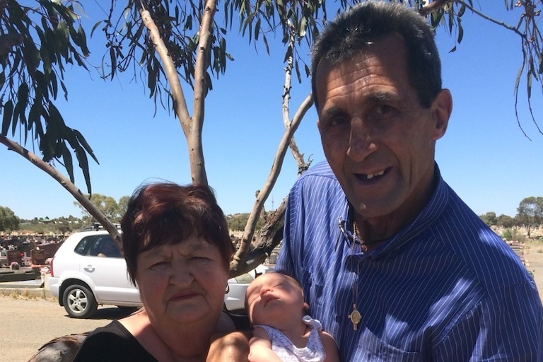 A man and woman holding a newborn granddaughter
