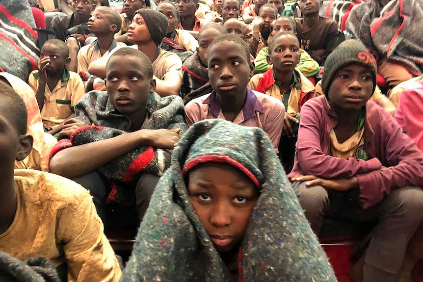 A group of boys, some with blankets over their heads