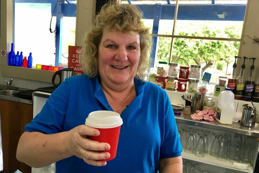 Derby cafe worker Vicky Way smiles and holds a red coffee cup.