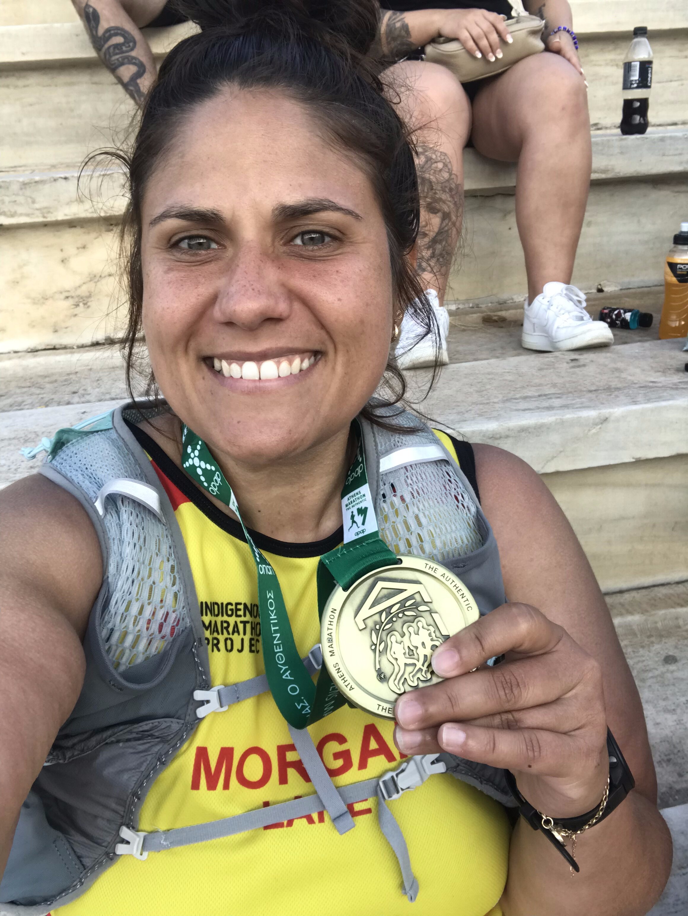A female marathon runner holds up her medal