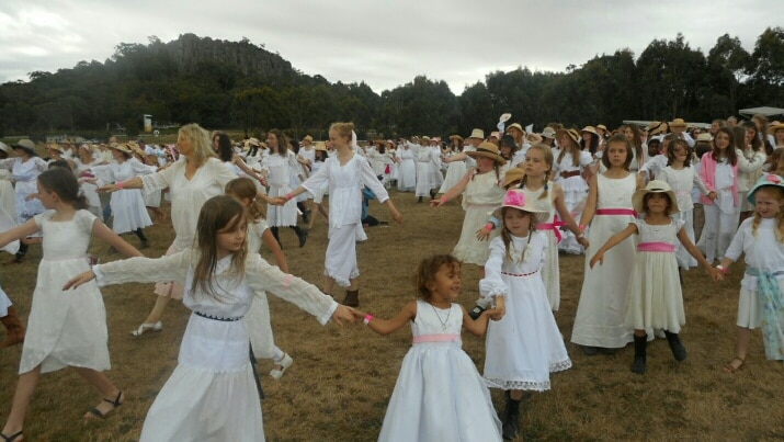 Dancers donned white lace dresses adorned with pink lace ribbons.