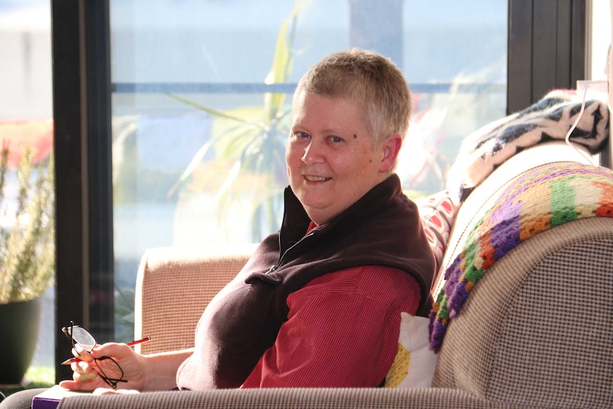 Rhonda Stewart sits in her home.