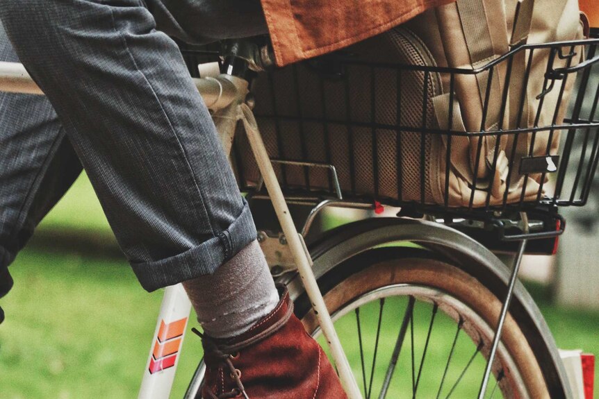 Close up of man wearing dress shoes on a commuter bike