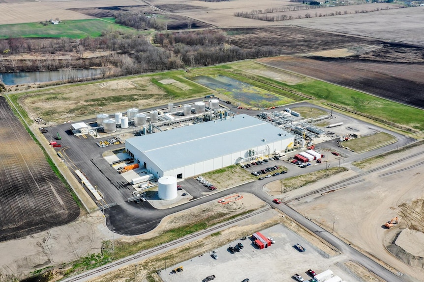 An aerial shot of a factory in a field.