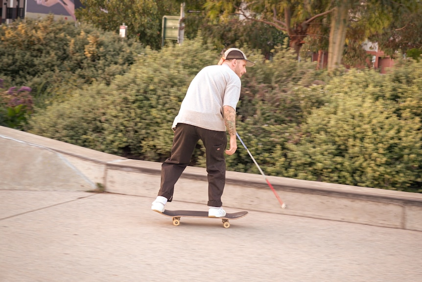 An action shot of Richard Moore riding a skateboard at a skate park