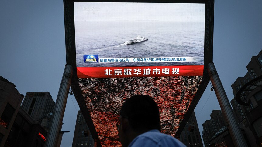A person stares at a television screen where a boat is floating in an ocean of water.