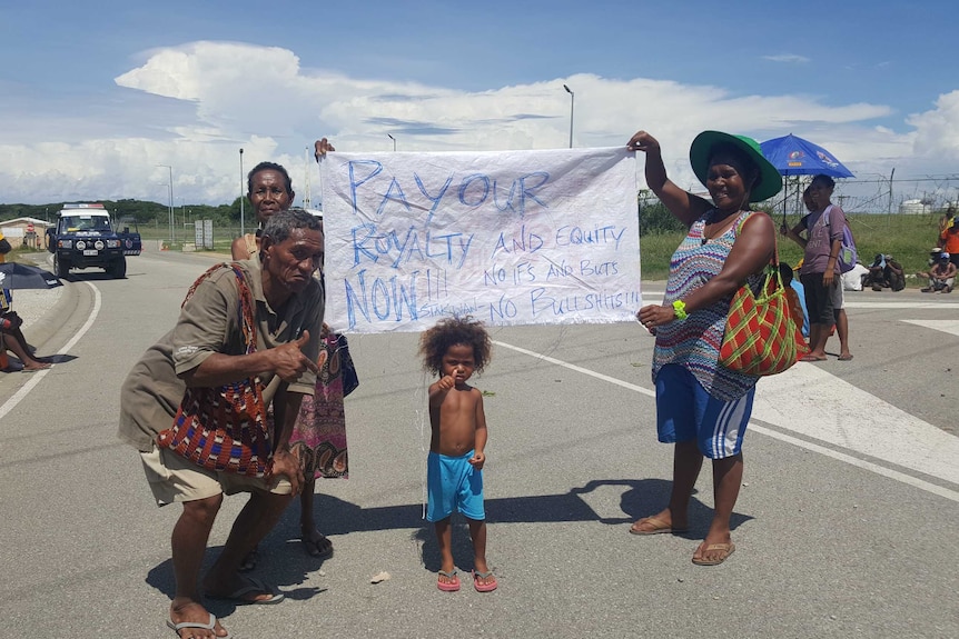 Protesters in Papua New Guinea hold a sign saying 'Pay our royalty now!!! And equity. No ifs, ands, buts. No bullshit!!!'