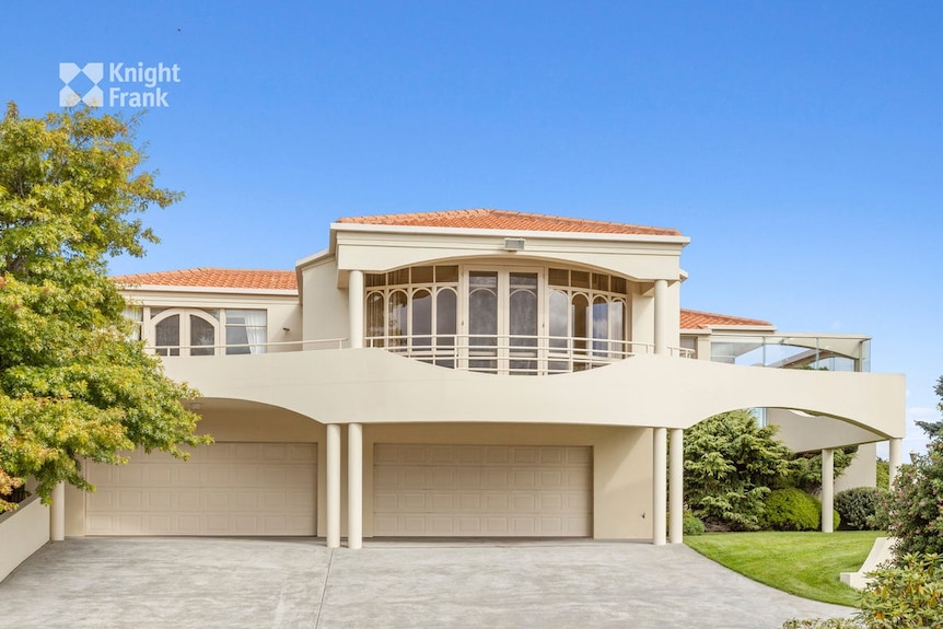 A front view of the house shows a double garage and an expansive second floor.