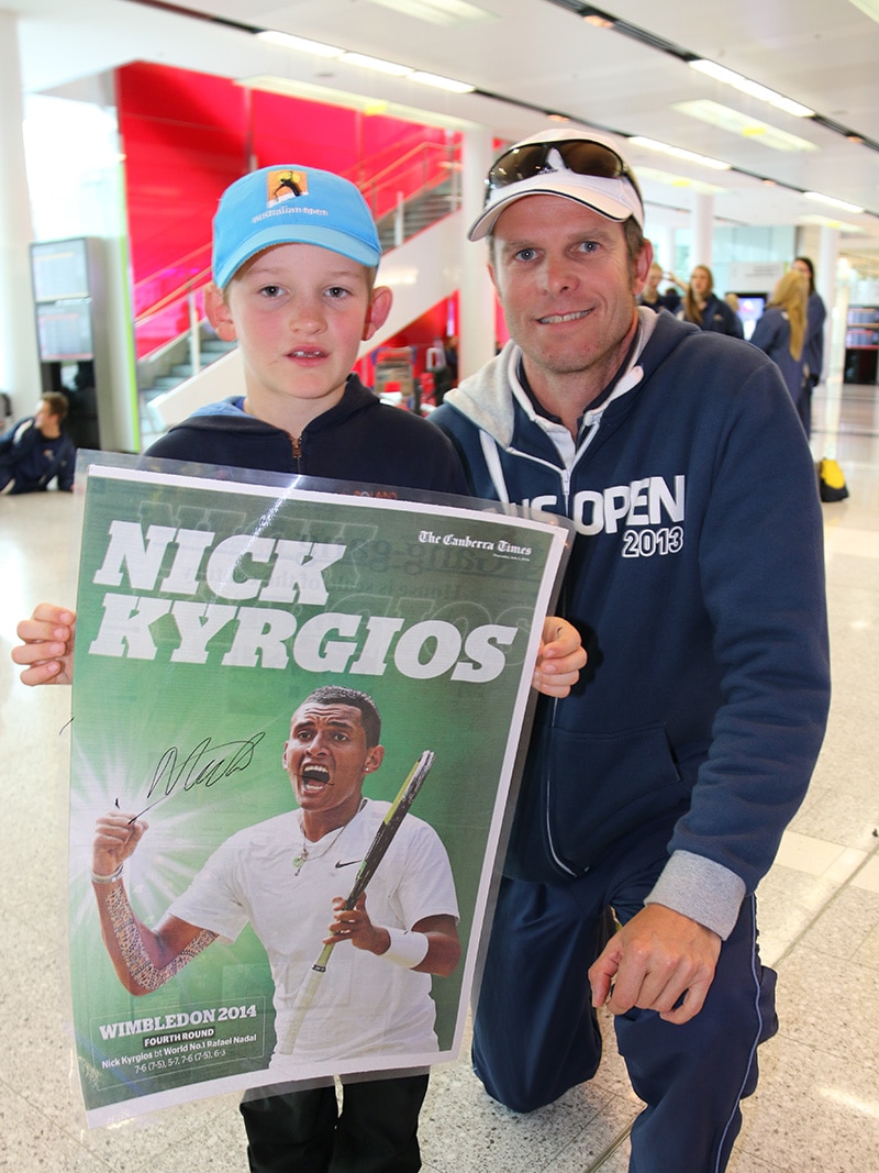 Charlie, 7, and Olivier Camus wit the poster Charlie got autographed by Nick Kyrgios at Canberra Airport.