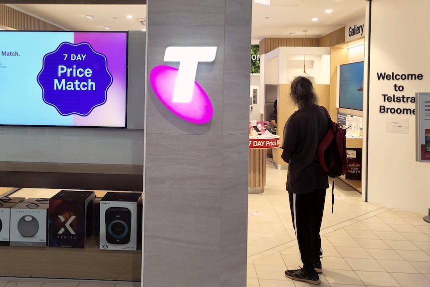 A Telstra store in a mall, with a man standing out the front. Sign says Welcome to Telstra Broome.