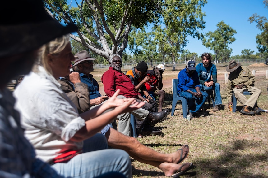 A group of people sit in a circle. 