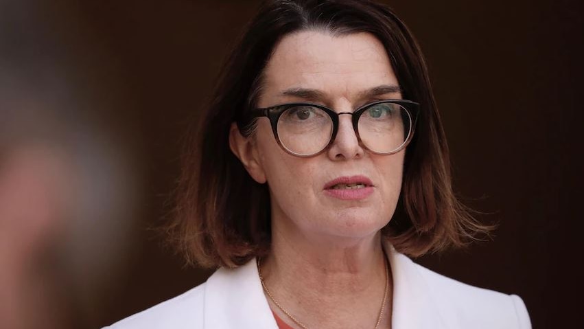 Social Services Minister Anne Ruston wearing white jacket and dark glasses with blurred background