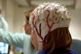 A girl connected with cables for EEG for a scientific experiment.