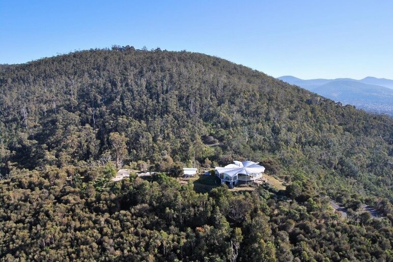 an aerial photo of a house sitting in vast bushland