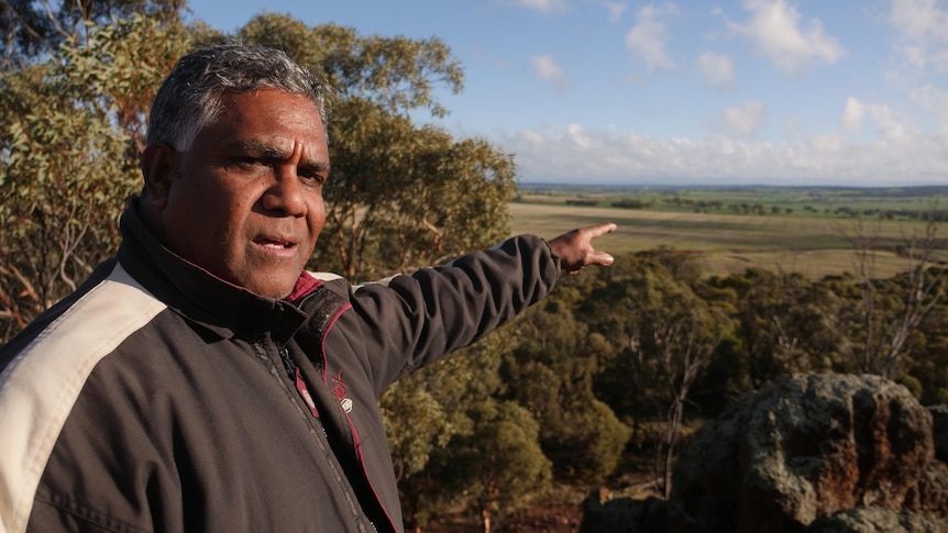 a man points toward trees in the West Australian Wheatbelt