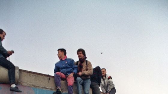 Young West Berliners perched on top of the wall in 1989.