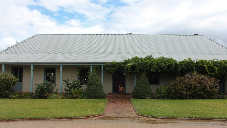 An old tin roofed colonial style house with verandah