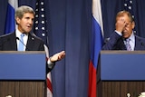 John Kerry gestures as Sergei Lavrov puts his hand on his face