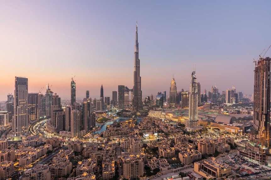 Wide shot of a dense city skyline at sunset.