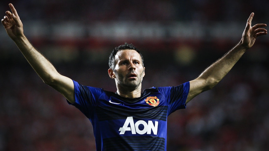 Giggs raises his arms in the air