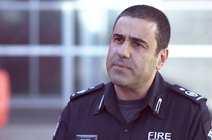 Steve Attard wears a blue uniform that says "fire rescue" on the front