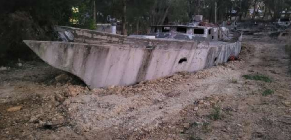 A concrete boat was buried in mud. 