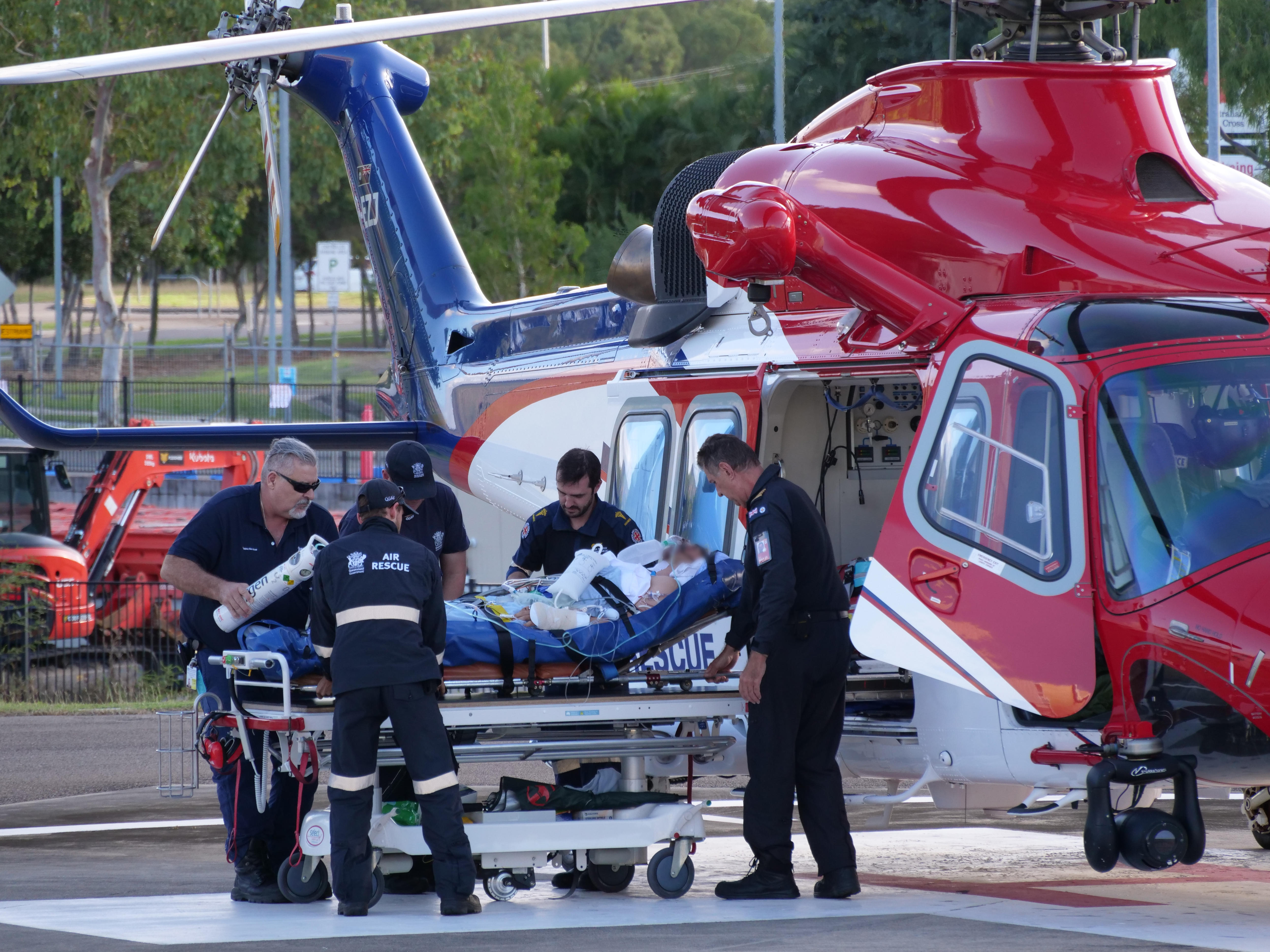 A person is stretchered out of a helicopter.