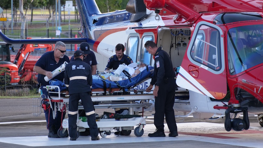 A person is stretchered out of a helicopter.
