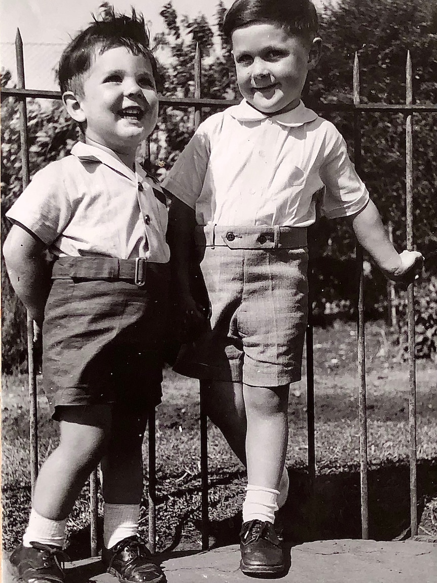 A black and white photograph of two young boys it collared shirt tuced into shorts