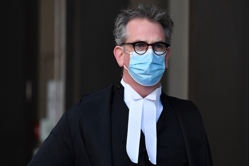 A man wearing a surgical face mask walking 