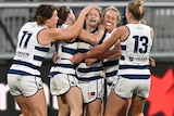 A group of Geelong players swarm around Georgie Prespakis to celebrate with her